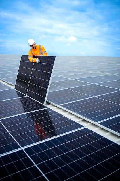 Installing solar power plant as sustainable energy source worker placing solar panel on the roof _ Premium Photo